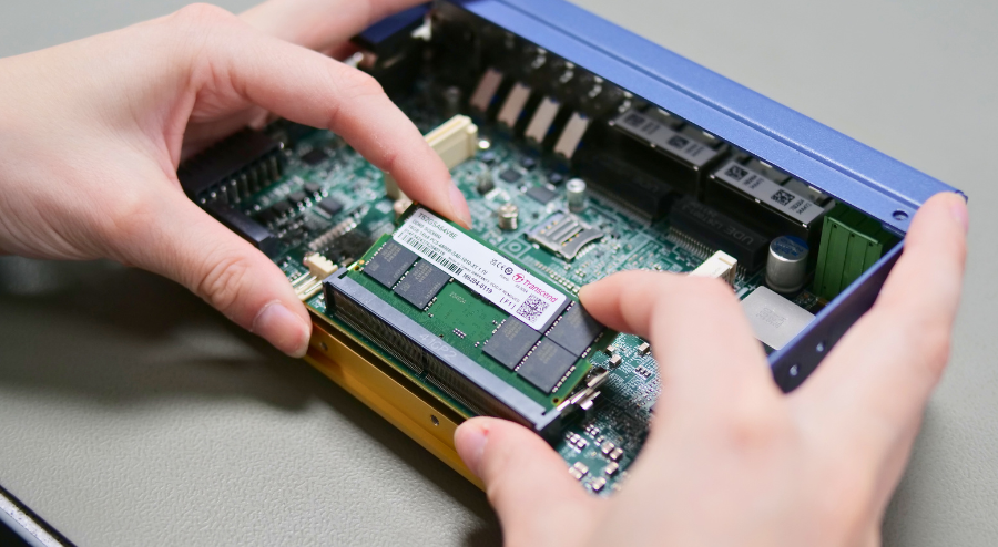 Technician inserting component into an embedded computer 